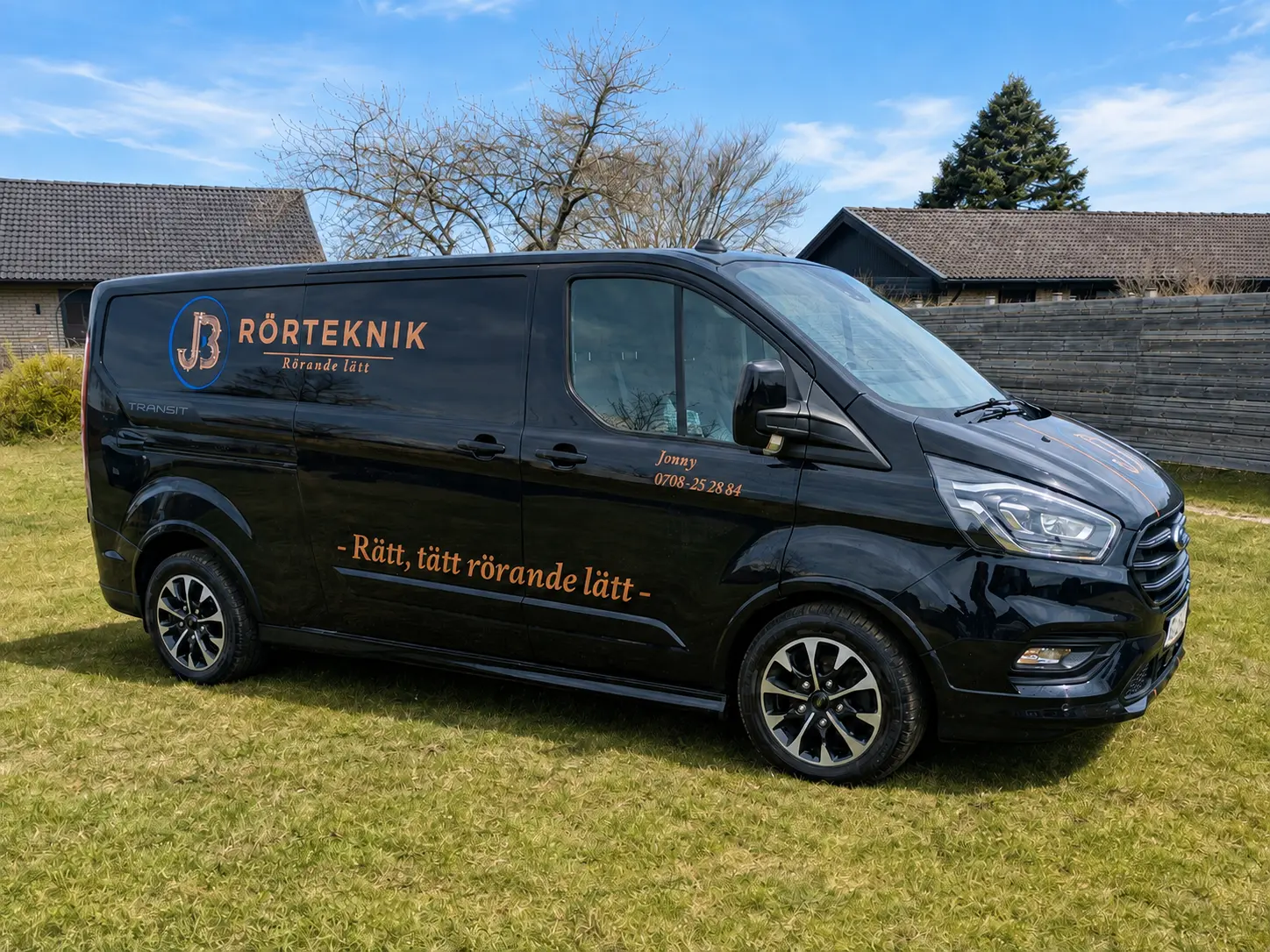 JB Rörtekniks svarta servicebil i Sjöbo en solig dag